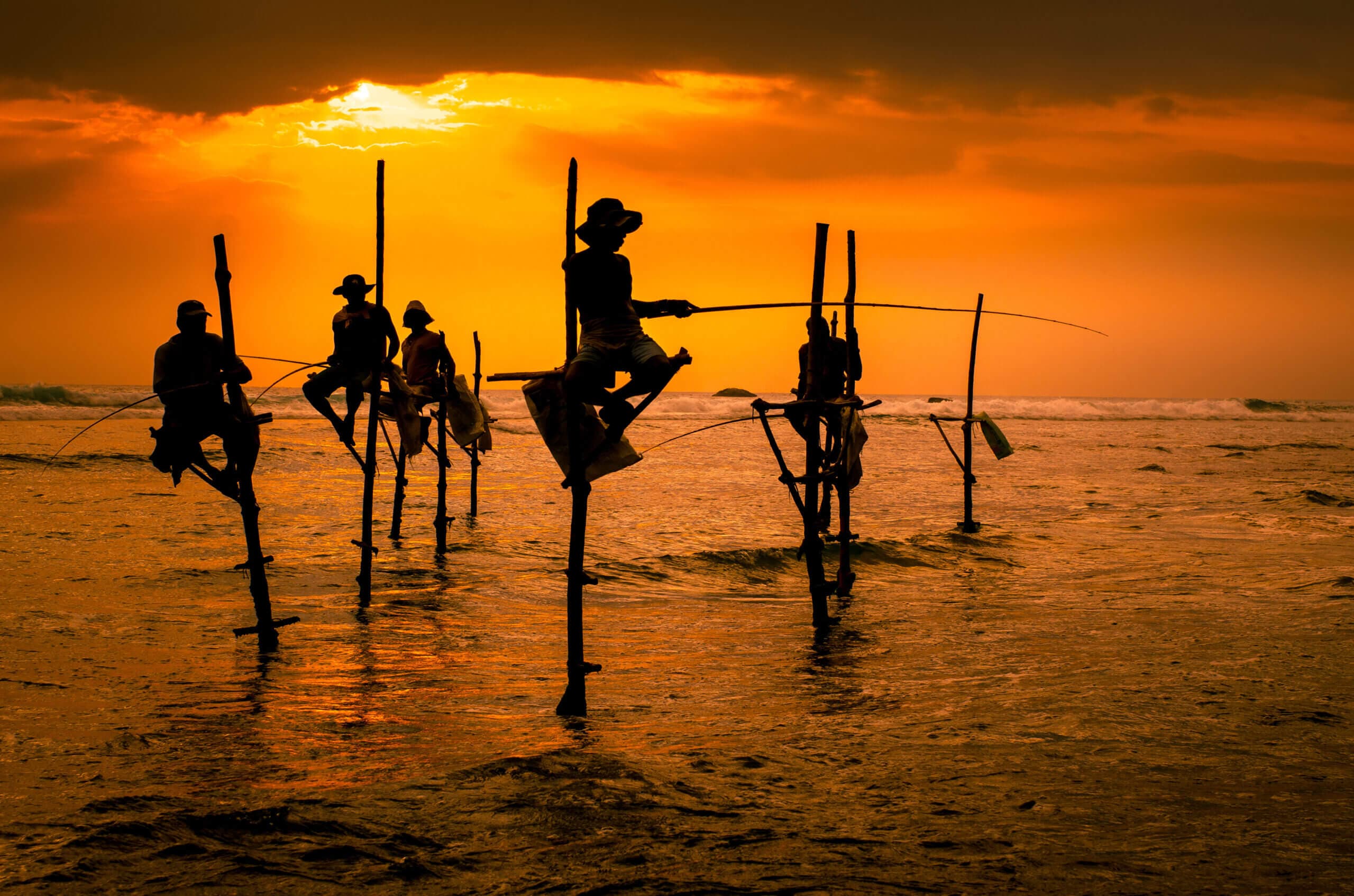 Stilt fishermen at sunset